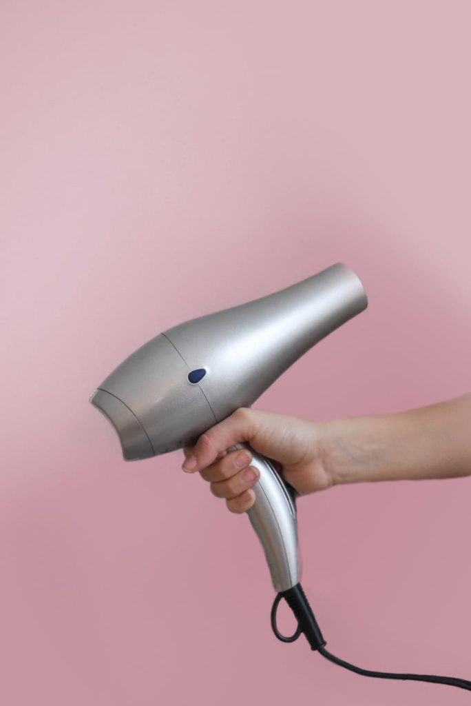 person holding grey hair dryer